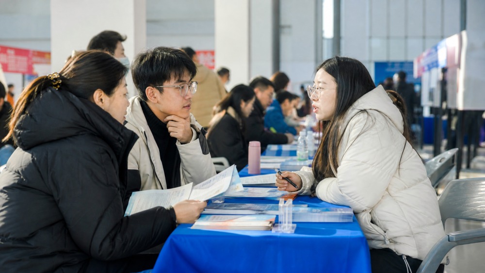 工作人员与市民在社区活动现场交流政策
